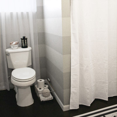 finished bathroom with striped walls 