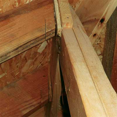 improperly cut rafter shaved and shimmed into place