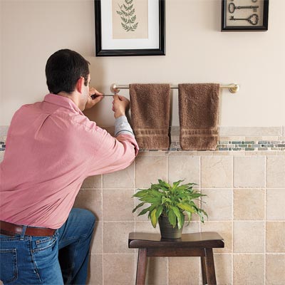 man tightening loose towel rack