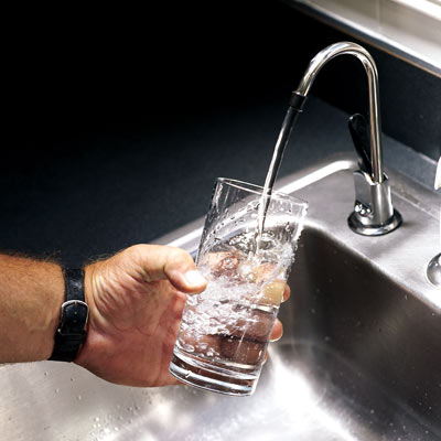 man running water into a drinking glass