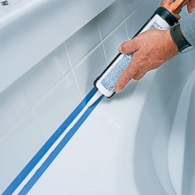 man caulking around a tub