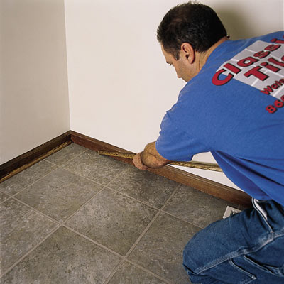 man laying a vinyl tile floor