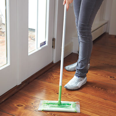 Using wax paper as a mop head to pick up dirt