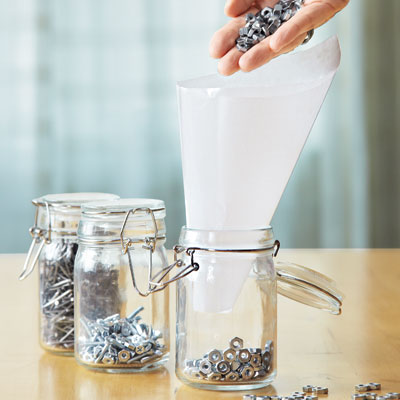 funneling small nuts into a mason jar with wax paper