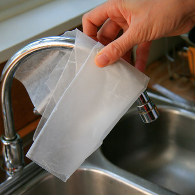 polishing a kitchen faucet with wax paper