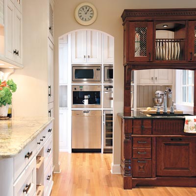 old world style kitchen with arched doorway to pantry with stainless steel appliances