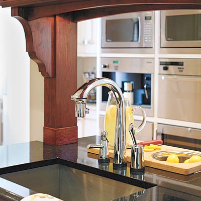 old world style kitchen with back to back sinks and black granite countertops