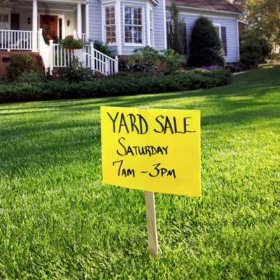 house with yard sale sign on lawn