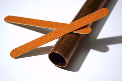 Emery board to grind burrs off pipe