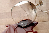 glass of red wine spilled on hardwood floor