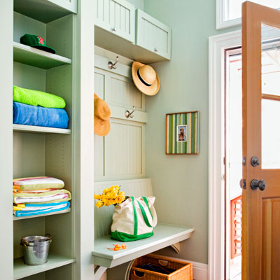 cottage style entryway turned mudroom with shelves, bench and tilt-up cabinet doors