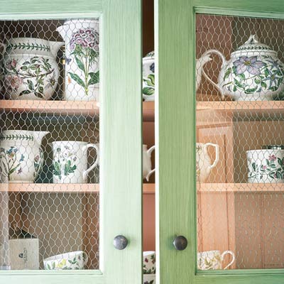 cottage style cabinets with chicken wire behind glass fronts