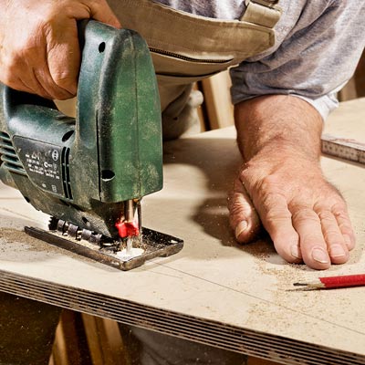 man cutting wood with saw 