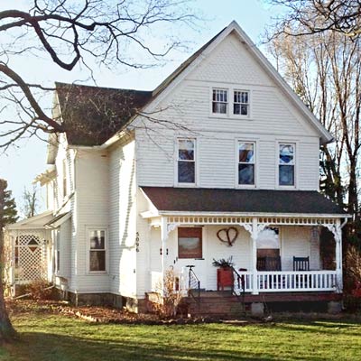 photo of an all-white farmhouse before a Photoshop redo