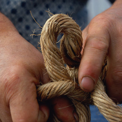 person tying a rope knot