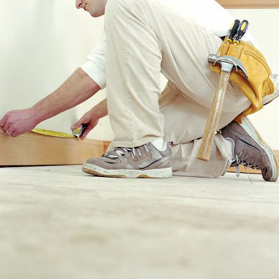 man measuring baseboard