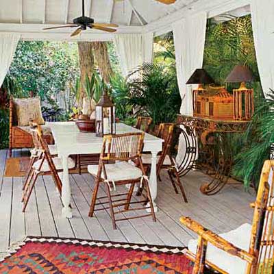 a covered patio furnished in the British Colonial style