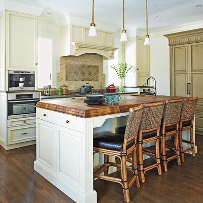 neutral kitchen with a walnut countertop, gray-olive woodwork and tumbled tile backdrop