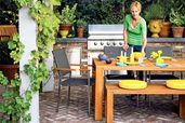 a woman sets a table in an outdoor kitchen/dining area