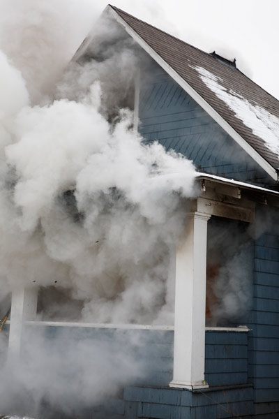 smoke from house fire escaping through house windows