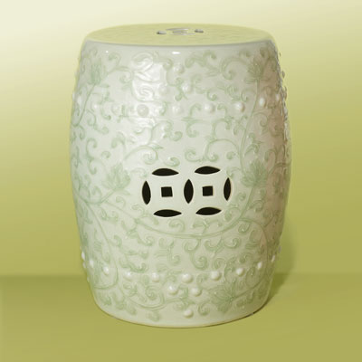a white ceramic garden stool with a green vine pattern