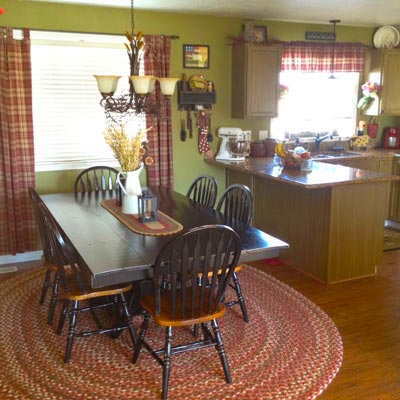 kitchen with farmhouse-style table, red accents and green walls