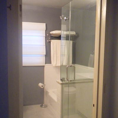 bath with gray walls, glass shower