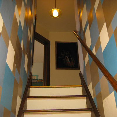 stairway walls painted with blue, brown and off-white geometric pattern 