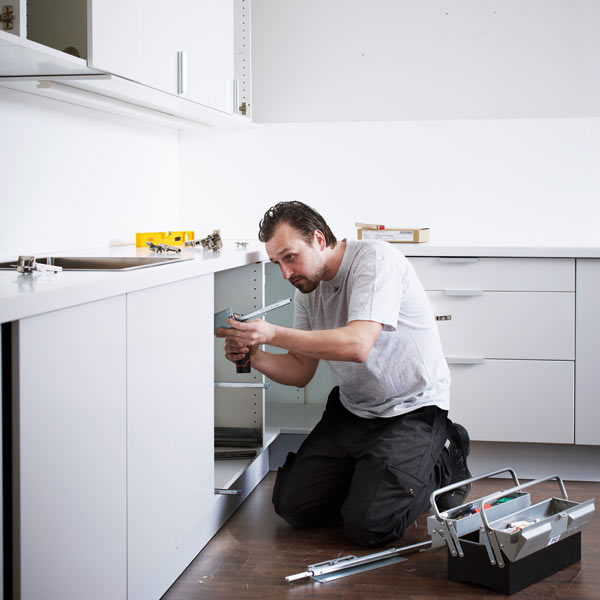 man installing kitchen cabinets
