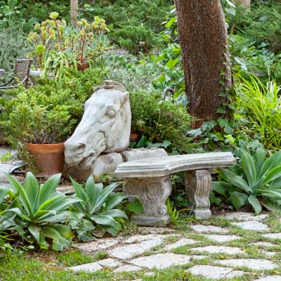 garden bench with concrete horse's head 