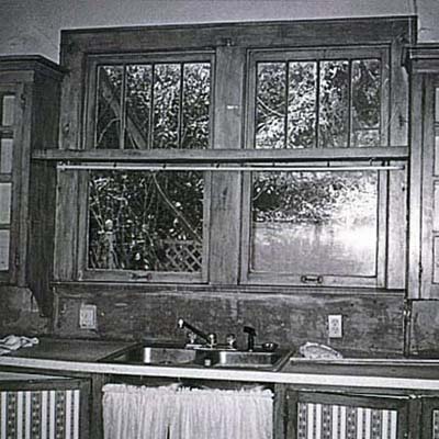 before of kitchen with wood panels and wallpapered cabinets