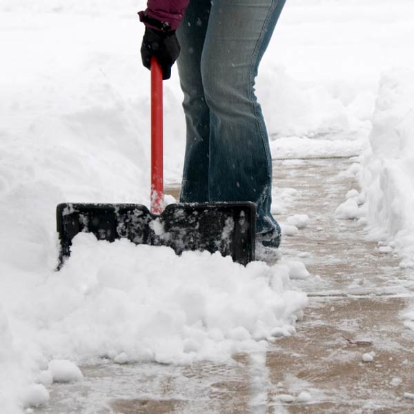 person shoveling snow on walkway or driveway