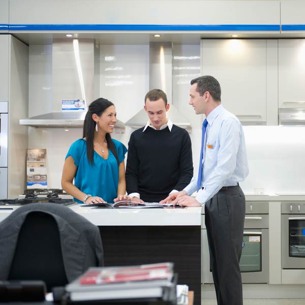 young couple talking to appliance salesman