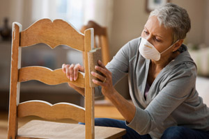 10 uses for sandpaper woman sanding paint off a wood chair