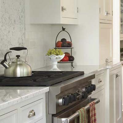 painted cabinets and beefy hardware in this remodeled shingle-style cottage