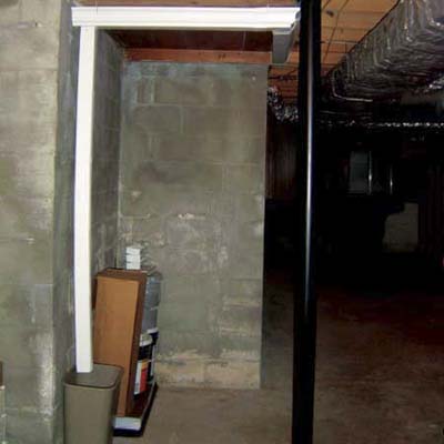 downspout spilling into wastebasket in crawlspace