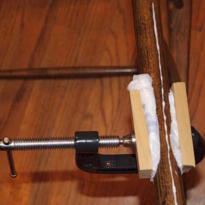 plastic bags wedged between dowel being glued and scrap wood used as clamping blocks