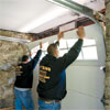 two workers lifting the last door section into place