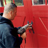 worker attaching the hardware to the outside of the new carriage-style doors