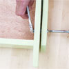 hands using an adjustable wrench and screwdriver to bolt the legs to the box