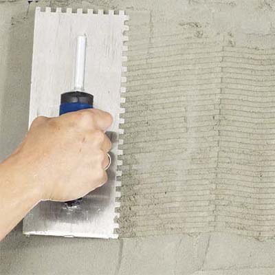 hand combing the scratch coat of a fireplace to create a stone veneer surround