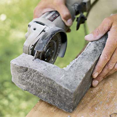 hand scoring the corner pieces of stone used to create a stone veneer surround