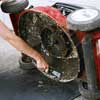 Clean the undercarriage of the mower, scraping away debris with a putty knife