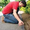 Mark Powers secures a chalk line on the edge of a driveway