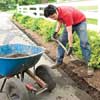 Mark Powers digs a trench next to an asphalt driveway