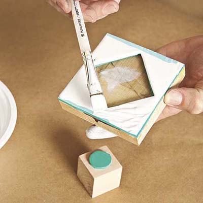 applying white paint to one of the stamps