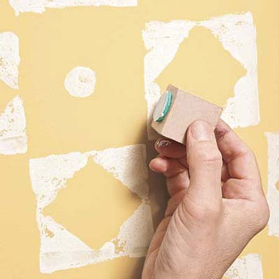 using the circle stamp on a yellow-painted wall