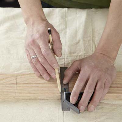 hands making the spindle locations for building a dog gate