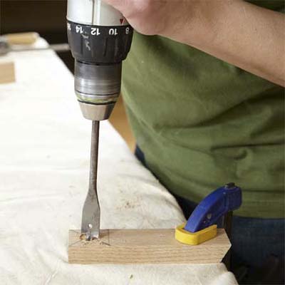 hands drilling one of the feet while building a dog gate