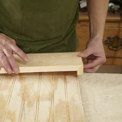 hands assembling fascia board and beadboard with caulk